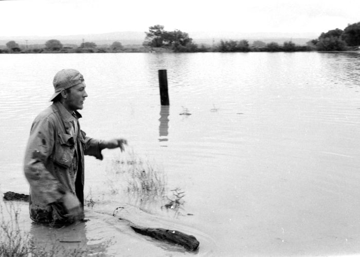 Farmer in his flooded fields farmer standing waste deep in water looking over his flooded fields.