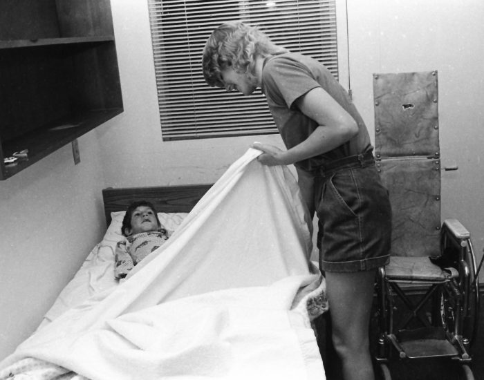 Tucking In A camp councilor tucking a boy into bed after a long, fun day at camp.