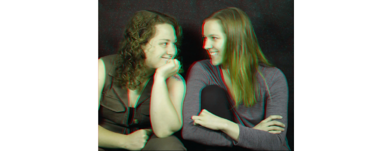 A stereo image of two lovely young women sitting side by side and smiling at each other