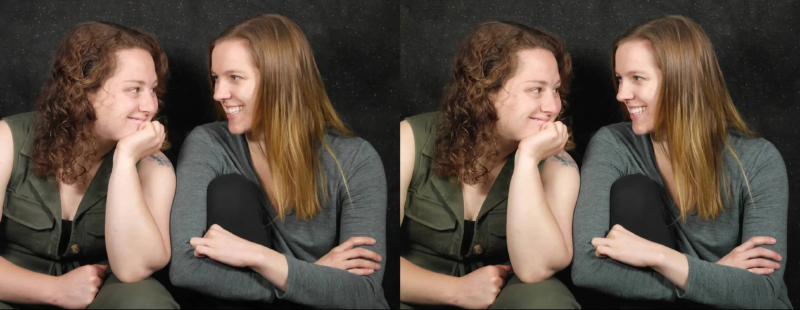 A stereo image of two lovely young women sitting side by side and smiling at each other