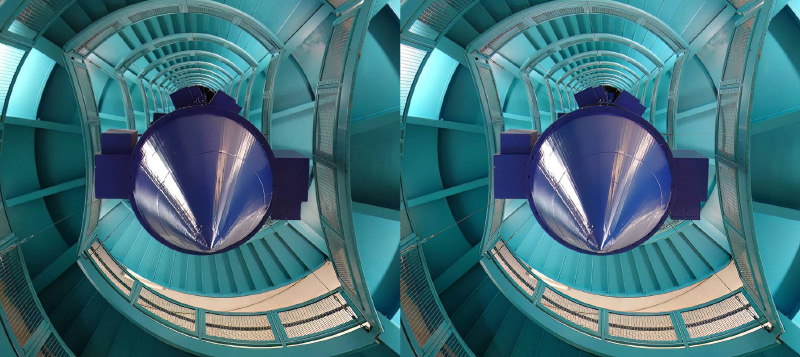 A stereo image looking up a modern stairway with a large blue cone pointing at the viewer.